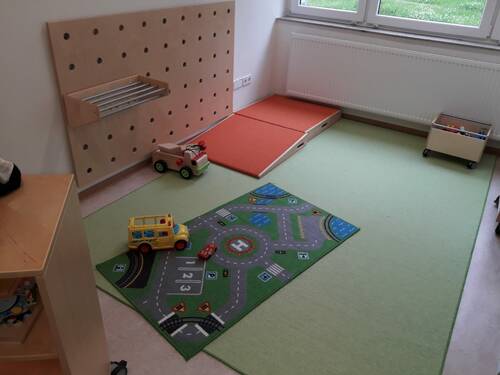 Vergrößert das Bild: "Spielecke mit verschiedenen Spielzeugen auf dem Boden"