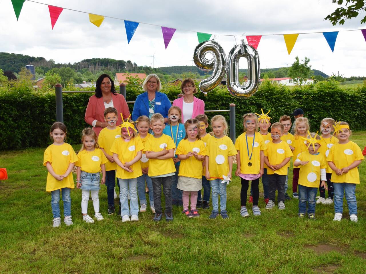 Allgemeine Vertreterin Vanessa Tegethoff, Leiterin Rita Rehermann und Bürgermeisterin Ute Dülfer freuen sich gemeinsam mit einigen Kindern des Familienzentrums über das Jubiläum. (Bild: Anja Ebner)