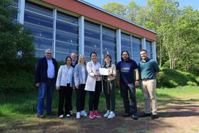 Förderbescheidübergabe für die Sanierung der Turnhalle Altenautal: Josef Meiwes (Ortsvorsteher Atteln), Anke Seemann (Konrektorin), Rüdiger Düchting (USC Altenautal), Isabell Wulf (Energiestadt Lichtenau), Regierungspräsidentin Anna Katharina Bölling, Bürgermeisterin Ute Dülfer, Markus Kremer (Schulleiter), André Klockenkämper (Ortsvorsteher Henglarn)
