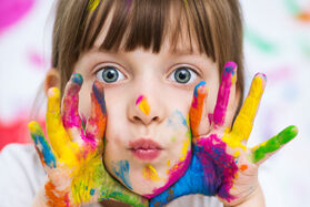 Mädchen mit bunten Handabdrücken