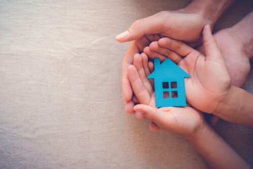 Hände halten ein Haus symbolisch in der Hand